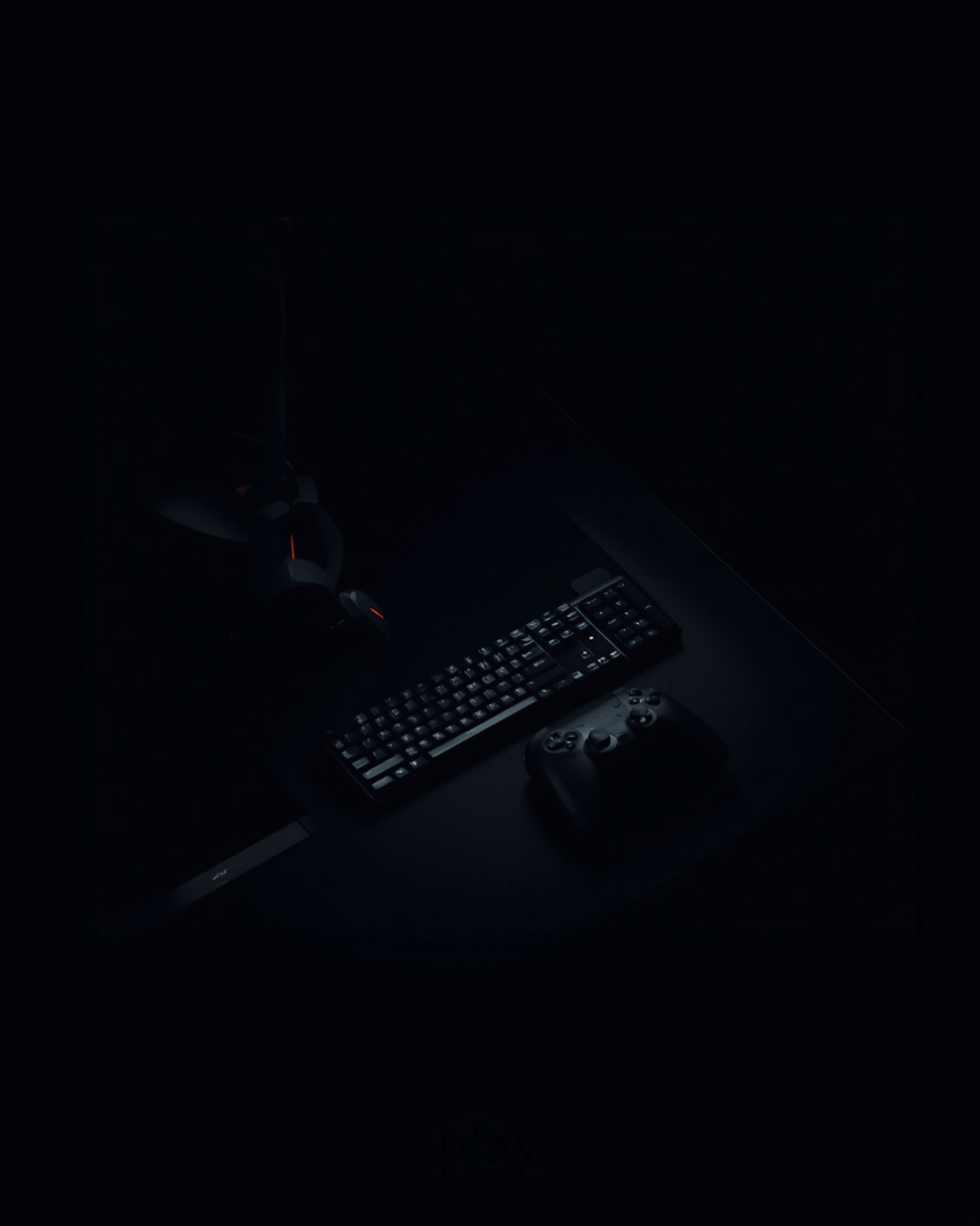 Dark gaming desk with a keyboard and a game controller